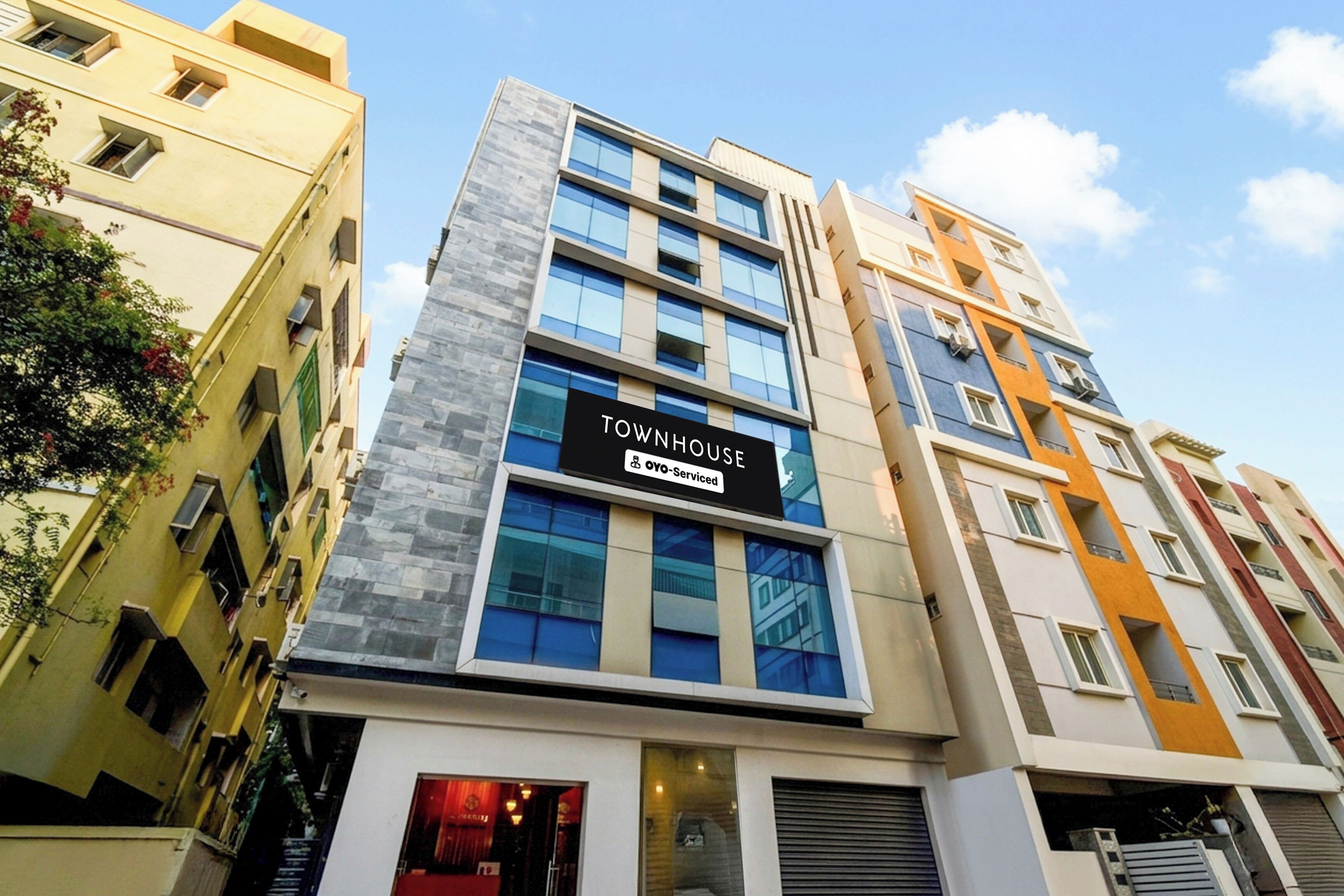 A multi-story building with a sign reading 'TOWNHOUSE OYO-Serviced'.
