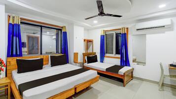 Habitación de hotel con dos camas, ventilador de techo y aire acondicionado.