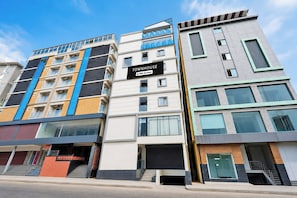 Un edificio de varios pisos con un letrero que indica que se trata de un complejo de apartamentos con servicios.
