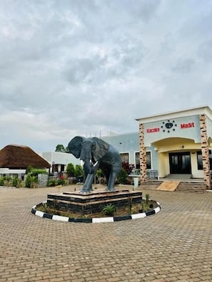 Un edificio con un letrero que dice 'Kacoke' y 'Madit' y una estatua de elefante en la parte frontal.