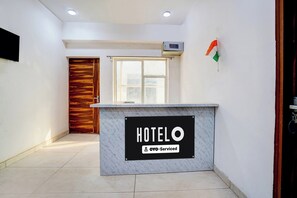 A hotel reception desk with a sign indicating 'HOTEL' and 'OYO-Serviced'. - Hotel O Sector 49 Noida (Noida)