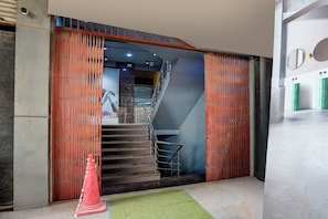 A staircase leading to an upper floor, flanked by wooden panels with a metal railing. - Hotel O Sector 49 Noida (Noida)