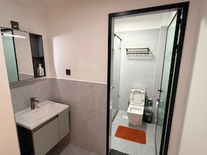 A modern bathroom with a glass-enclosed shower, a white sink, and a toilet. - Bellace Haven | Stylish Holiday Homes & Short-Stay Accommodation in Kenya (Nairobi)