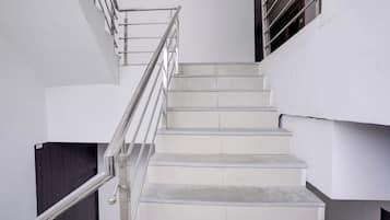 Una escalera con barandillas de metal y paredes blancas.