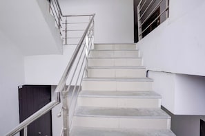 A staircase with metal railings and white walls.