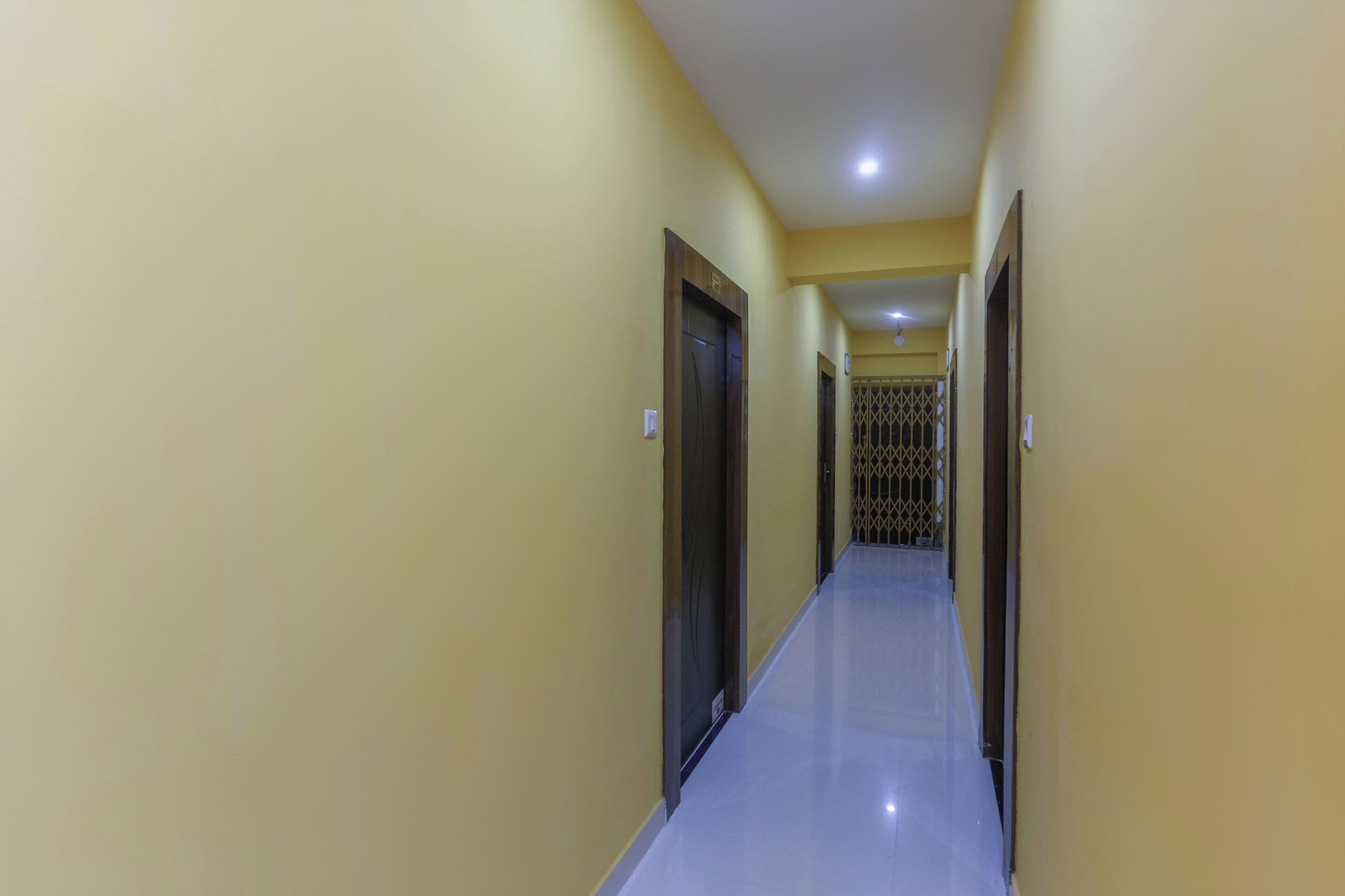 A long, narrow hallway with doors on both sides, leading to a gated area at the end.