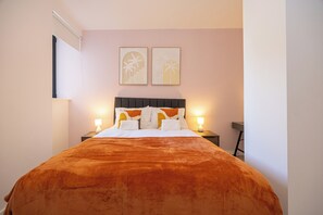 Ein Hotelzimmer mit einem Bett, zwei Nachttischlampen und zwei Wandbildern.
