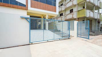 Ein befestigter Eingang zu einem Gebäude mit modernem Design, mit einem blauen Metallgitter und einem Betonboden.