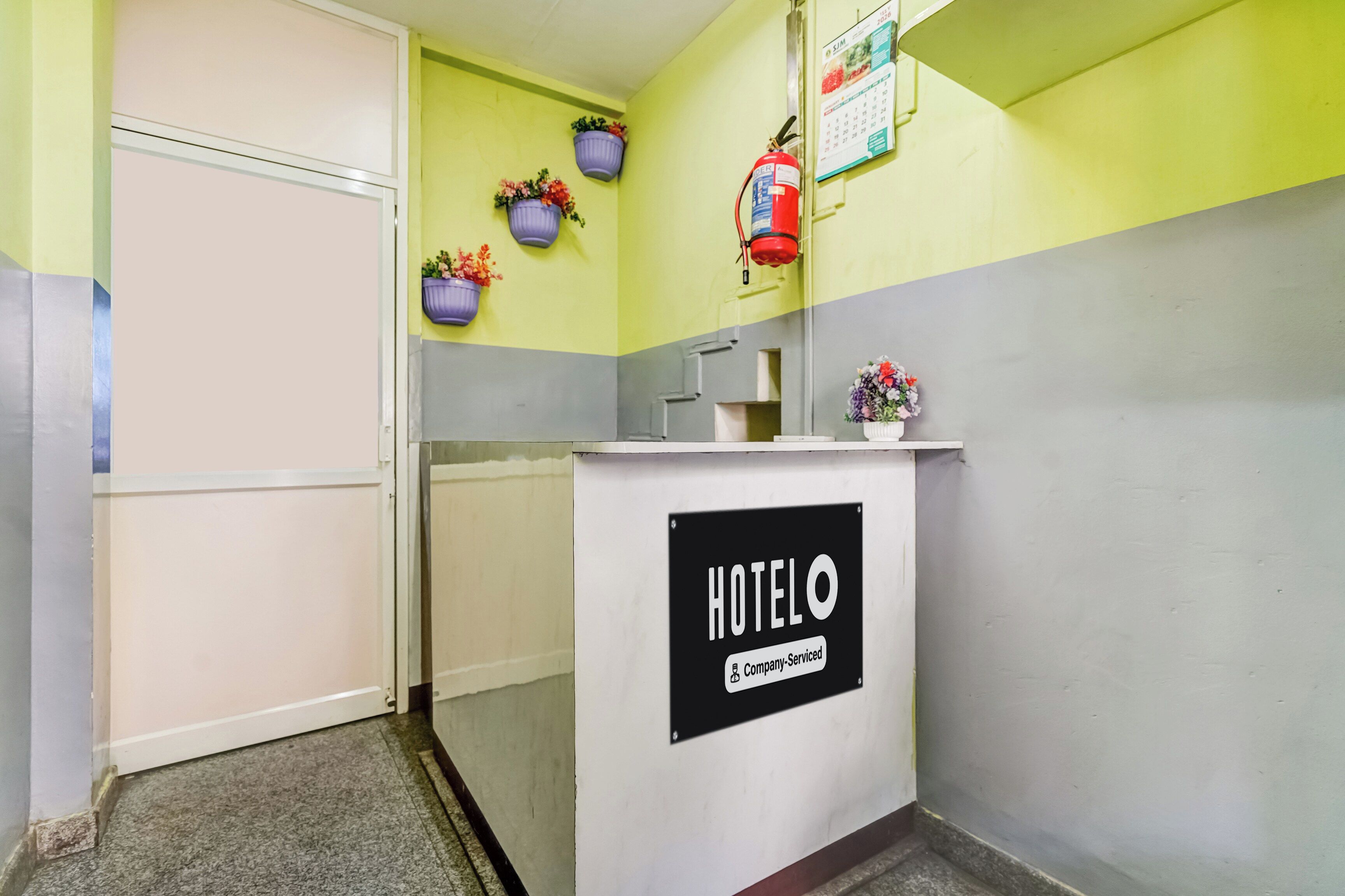 A reception area with a sign reading 'HOTEL' and a fire extinguisher mounted on the wall.