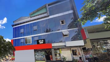 Un hotel con fachada moderna, múltiples ventanas y una entrada visible con escalones que conducen a la puerta.