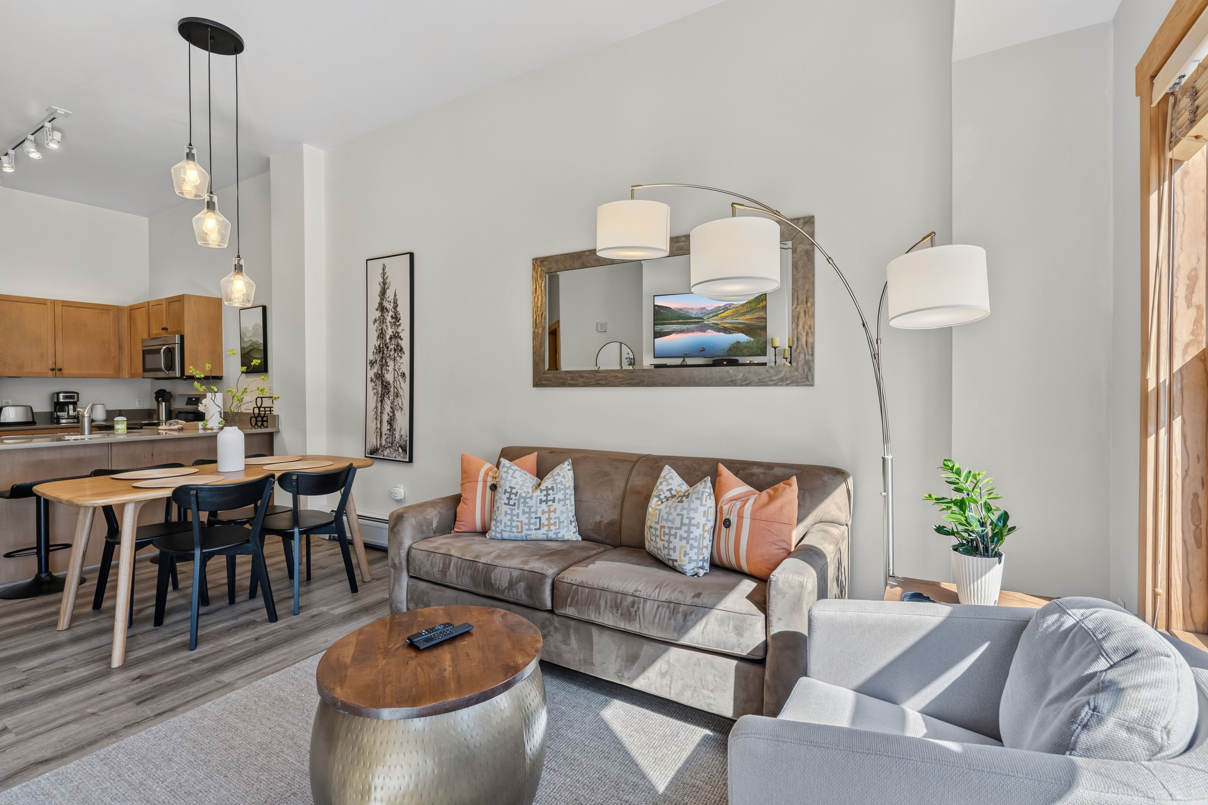 Ein modernes Wohnzimmer mit Sofa, Couchtisch und Essbereich.
