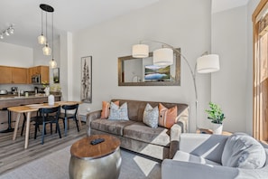 Ein modernes Wohnzimmer mit Sofa, Couchtisch und Essbereich.