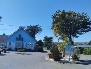 A blue building with a balcony, surrounded by vegetation and a clear sky. - New Listing (Binic-Étables-sur-Mer)