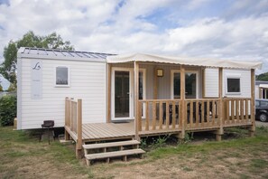 A mobile home with a wooden deck, a covered porch, and a small attached structure. - New Listing (Binic-Étables-sur-Mer)