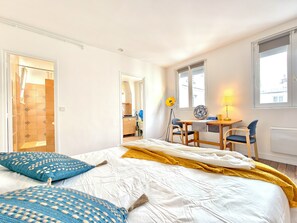 A bedroom with a bed, a desk, and a chair. - New Listing (Paris)