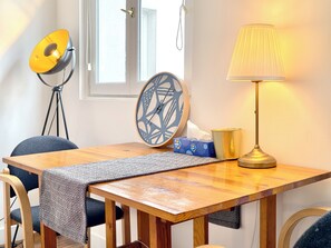 A wooden table with a patterned table runner, a lamp, a clock, and a tissue box. - New Listing (Paris)