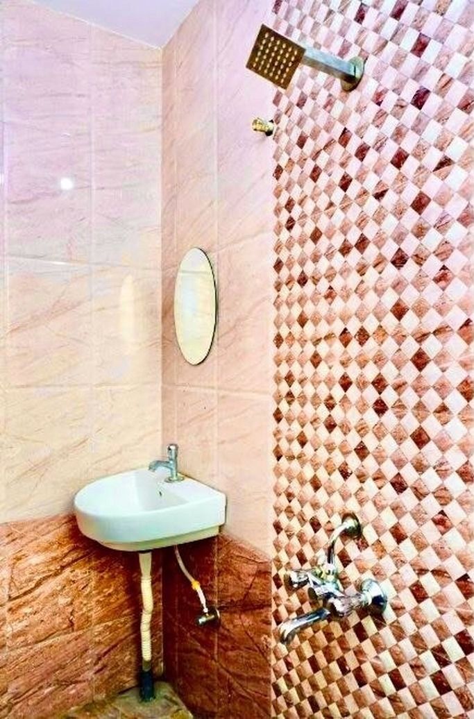 A bathroom with a sink, mirror, and shower.
