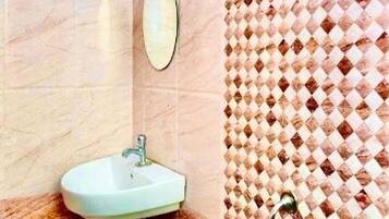 A bathroom with a sink, mirror, and shower.