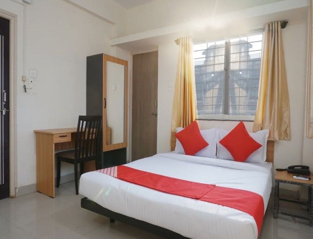 Quarto com cama, escrivaninha e cadeira.