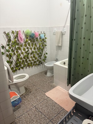 Ein Badezimmer mit Toilette, Bidet und Badewanne.