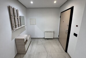 A modern bathroom with a wooden vanity, a mirror, a radiator, and a door. - Stylish Living at Kacem Palace (Tunis Governorate)