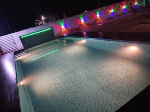 An outdoor swimming pool with a tiled floor and a low wall. - Hotel O CANARIES RETIREES RESIDENCY (Vanur)