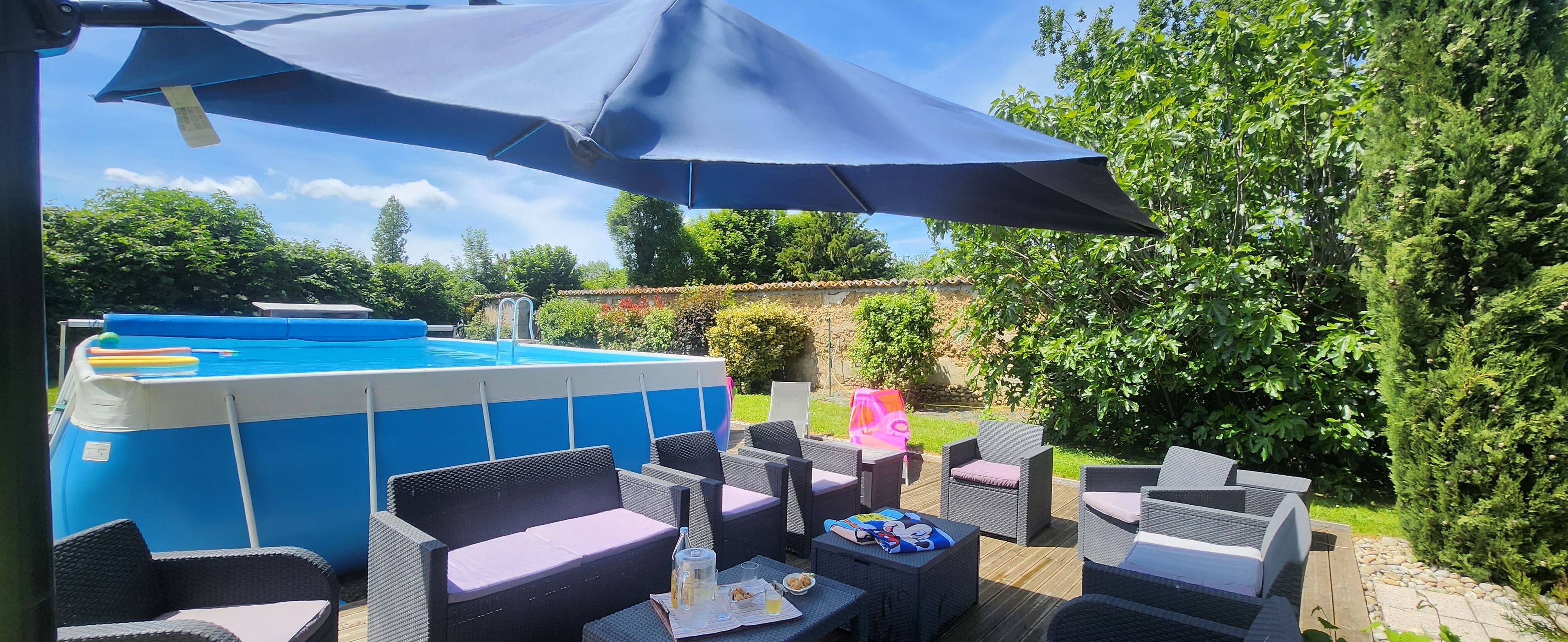 An outdoor seating area with wicker furniture and a pool.