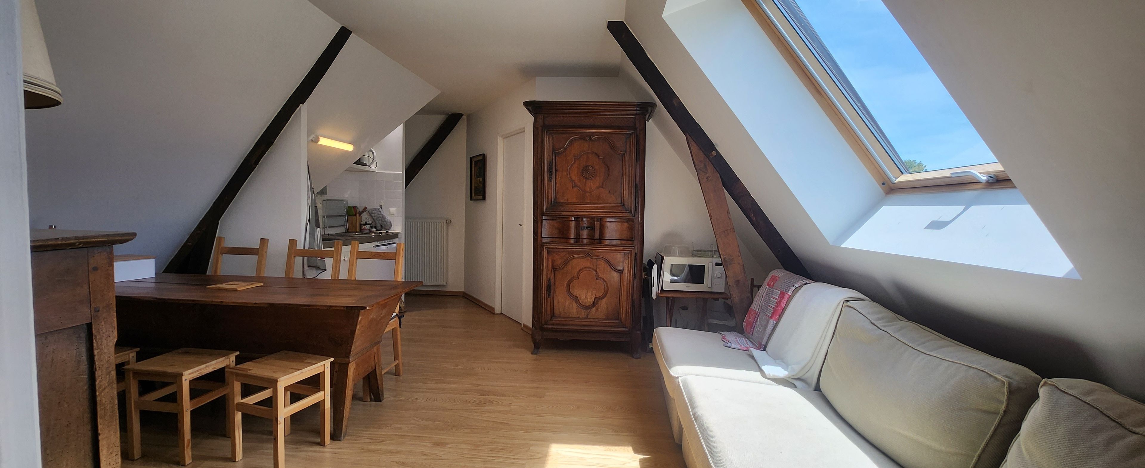 Una habitación estilo loft con comedor, sofá y armario empotrado.