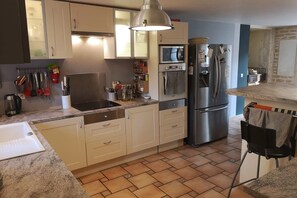 A kitchen with a built-in oven, a refrigerator, and a sink. - House 'La Ferme Tchoukar' 10 Minutes' Walk from the Lake (Bilieu)