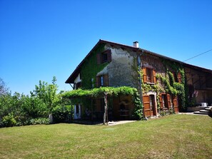 A two-story house with a sloped roof, wooden shutters, and a chimney. - House 'La Ferme Tchoukar' 10 Minutes' Walk from the Lake (Bilieu)
