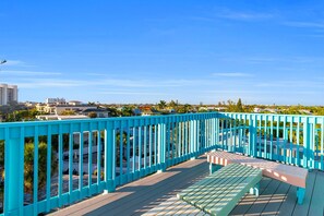 A blue outdoor deck with a bench and a view of a residential area. - Siesta Sunset Royale #3 1 Bedroom Apts (Siesta Key)