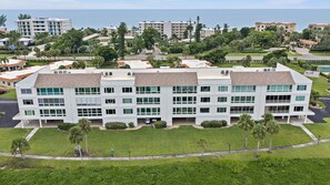 A multi-story hotel with a flat roof, large windows, and a parking area in front. - Windward Bay Penthouse Escape 2 Bedroom Condo (Longboat Key)