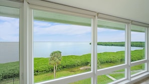 A view through a window with a clear sky and a body of water. - Windward Bay Penthouse Escape 2 Bedroom Condo (Longboat Key)