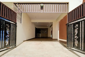 Un pasillo con piso de baldosas que conduce a una habitación con pared de mármol.