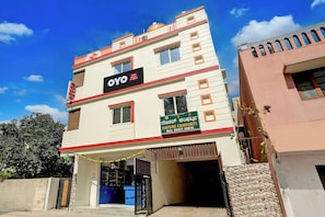 A multi-story hotel building with a prominent sign for 'OYO Hotel Nature Comforts' and a contact number. - Hotel O Nature Comforts (Bangalore)