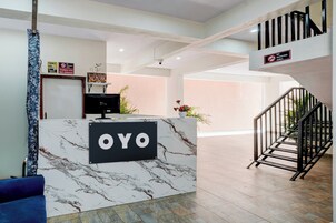 Una recepción con encimera de mármol y un cartel que dice 'OYO'.