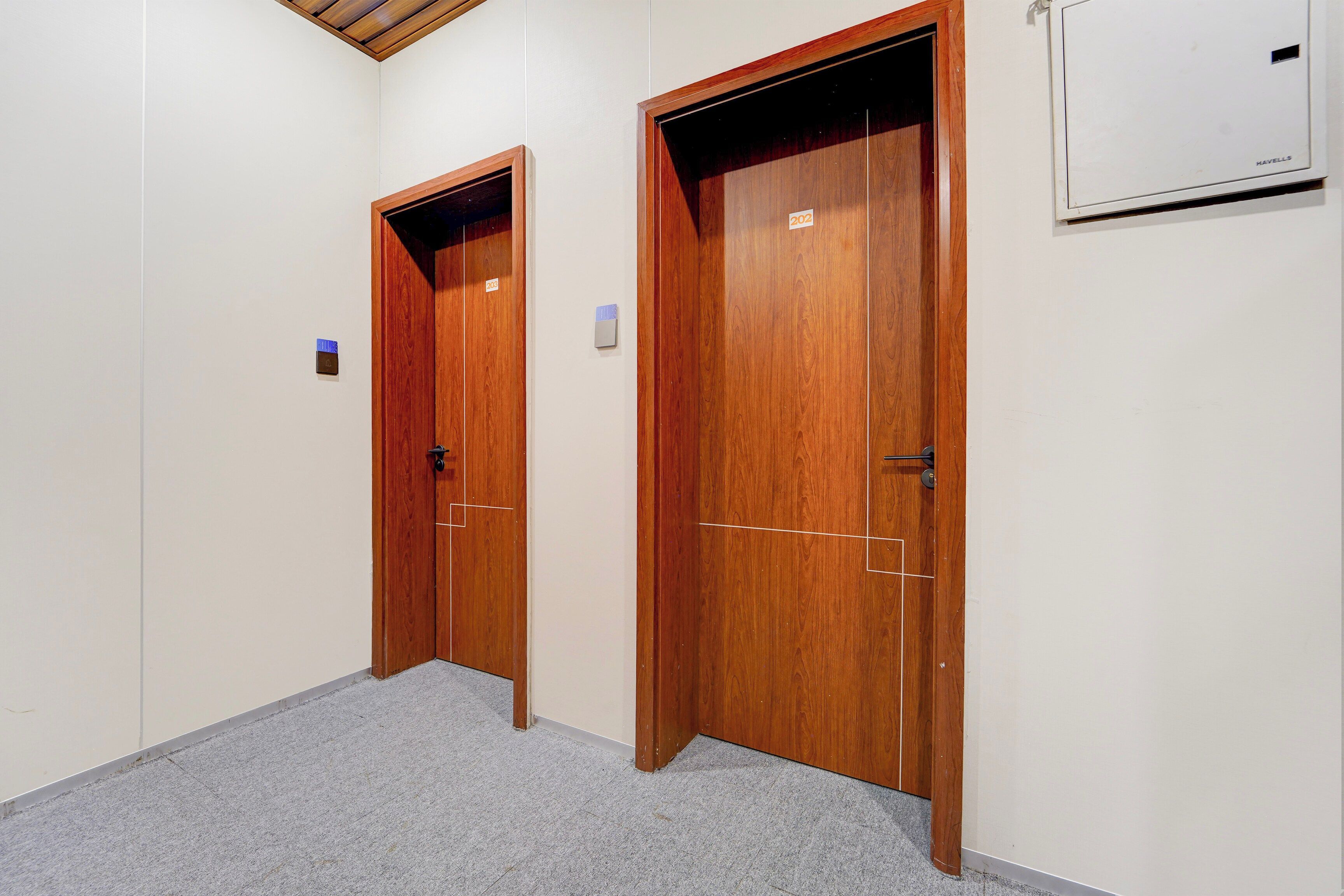A hallway with two wooden doors, one with a visible number '202' and the other with '203'.