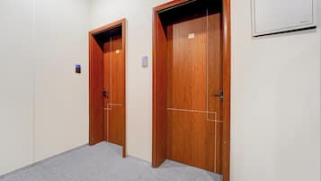 A hallway with two wooden doors, one with a visible number '202' and the other with '203'.