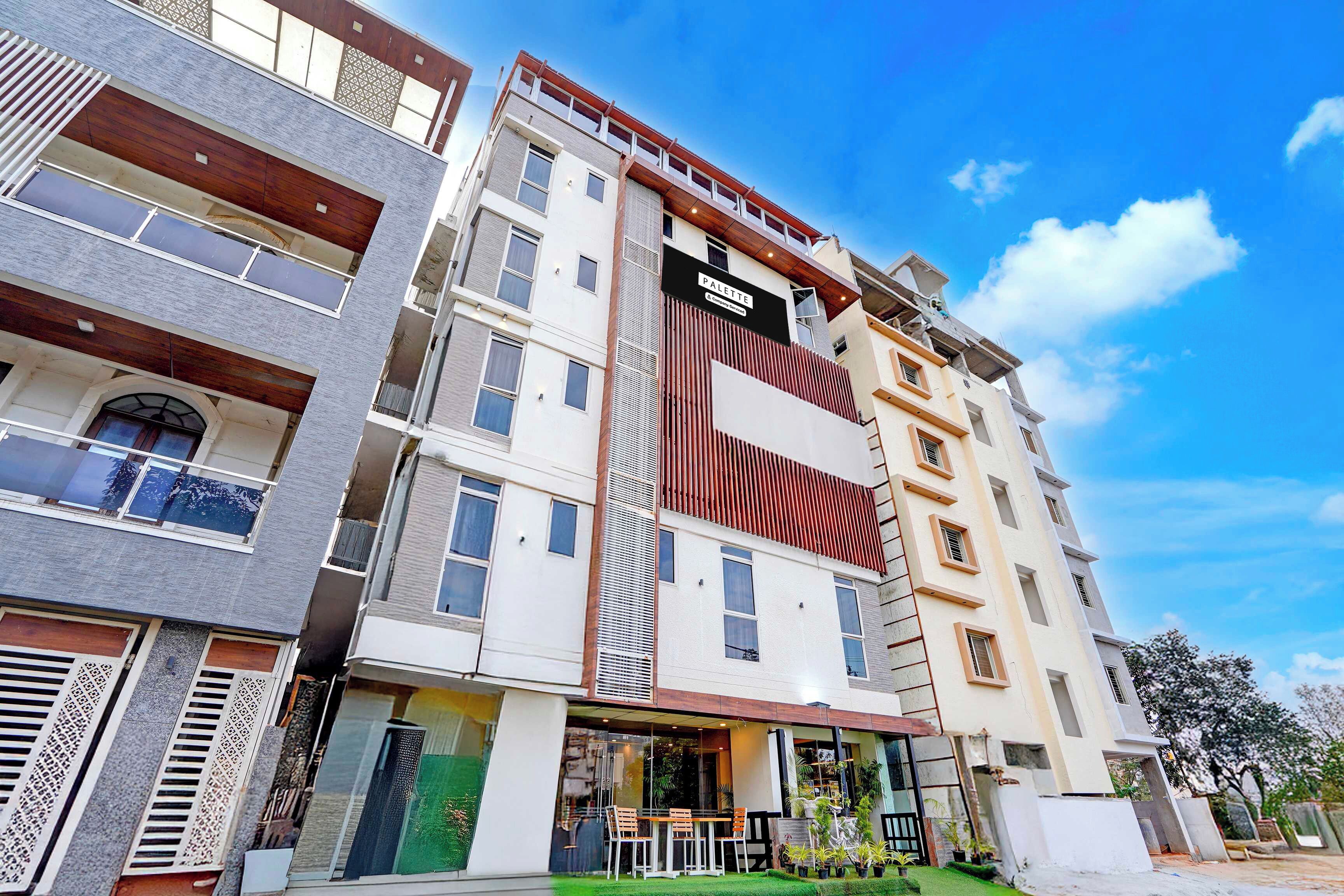 Edifício moderno com várias andares, janelas amplas e uma placa indicando serviços da empresa.