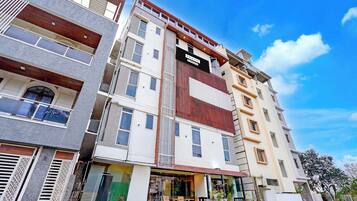 Edifício moderno com várias andares, janelas amplas e uma placa indicando serviços da empresa.