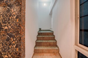 A staircase with a granite wall on one side and a window on the other. - Palette Hotel and Resort Manyata Tech (Bengaluru)
