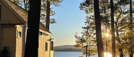 A house with a view of a lake and mountains in the distance.