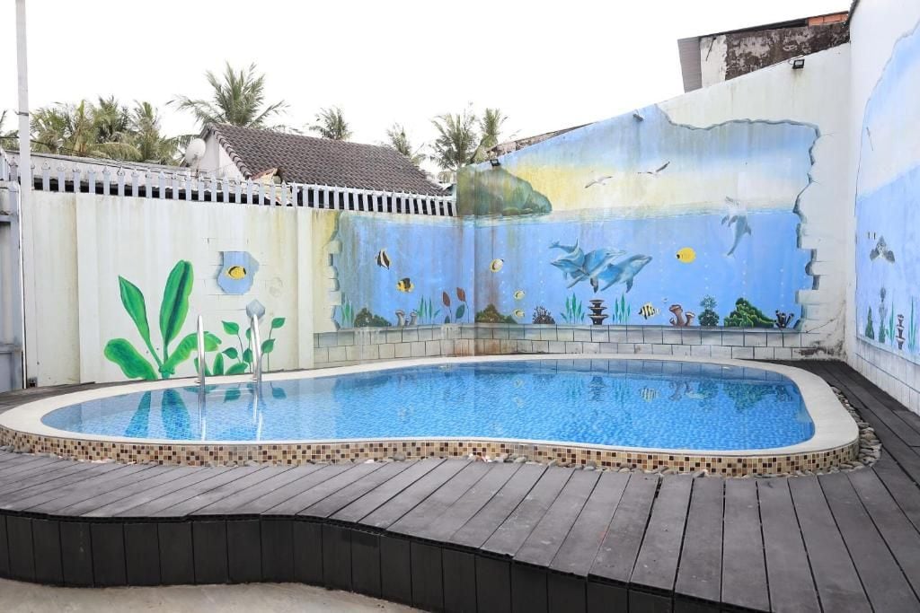 A swimming pool with a tiled deck and a mural depicting underwater scenery.