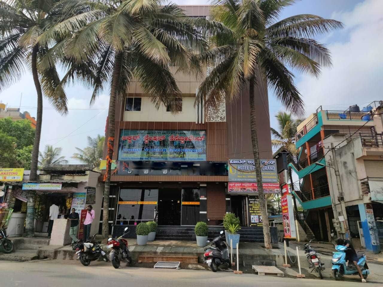 A hotel with a modern facade, multiple balconies, and a signboard advertising hotel services.