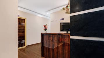 A reception desk with a wooden finish and a sign that reads 'Collection'.