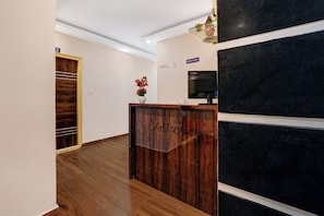 A reception desk with a wooden finish and a sign that reads 'Collection'. - Collection O Utsav Grand RR Nagar (Bangalore)