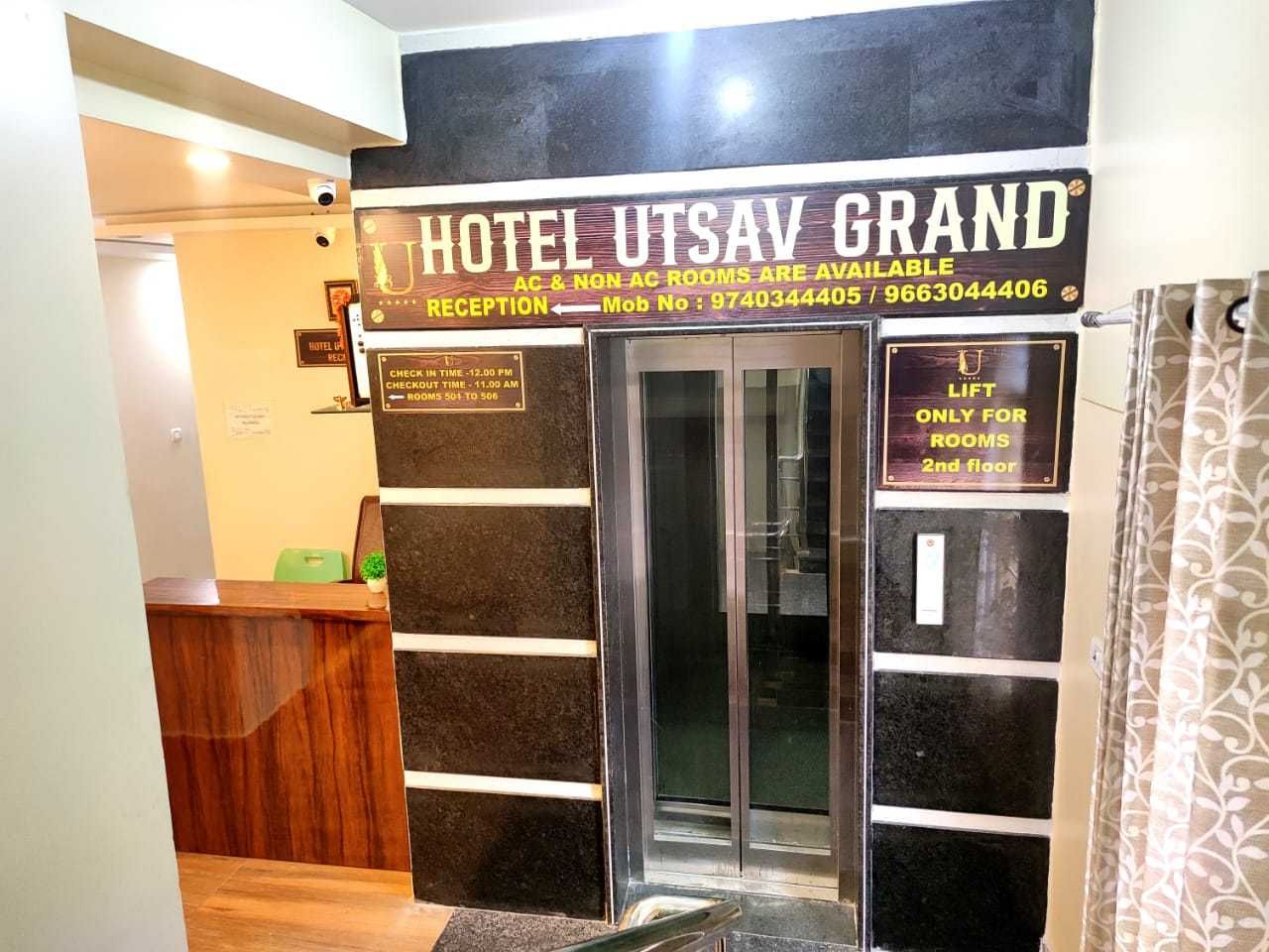 A hotel entrance with a reception desk, a check-in counter, and a sign indicating room availability.
