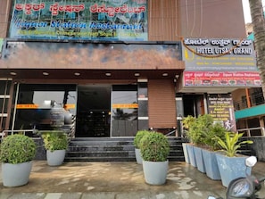 A building with a liquor station and restaurant offering vegetarian and non-vegetarian Chinese cuisine. - Collection O Utsav Grand RR Nagar (Bangalore)