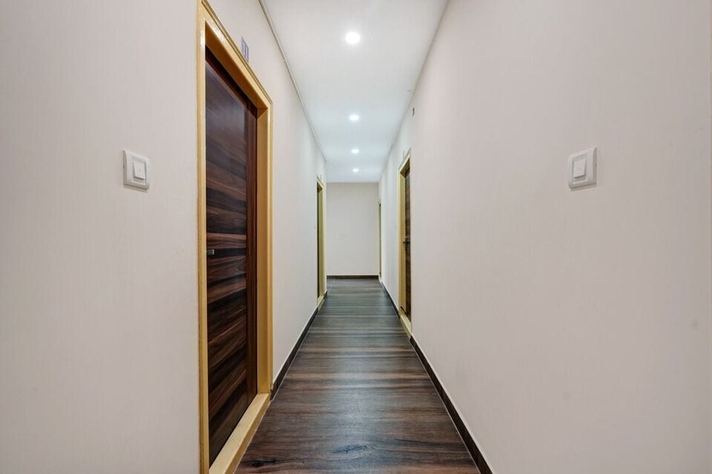 A narrow hallway with wooden flooring and white walls.
