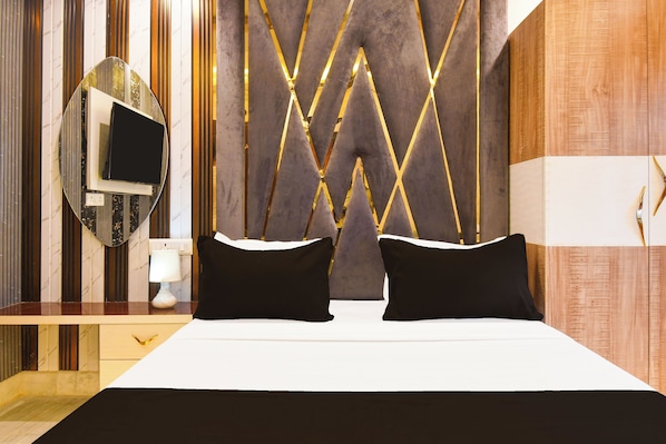 Una habitación de hotel moderna con una cama, un televisor y una mesita de noche.